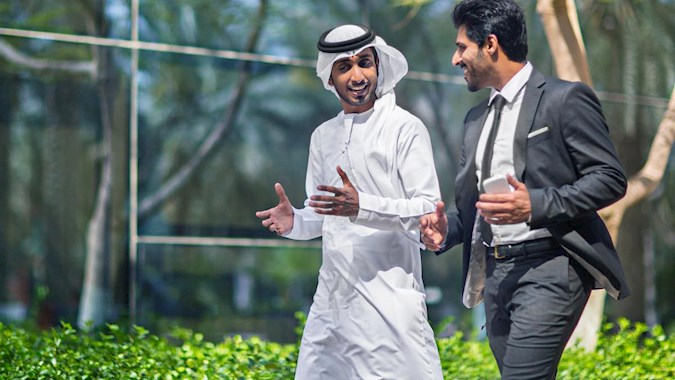 Emirati businessmen talking in the street