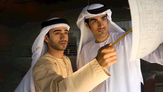 Emirati men studying a real estate project